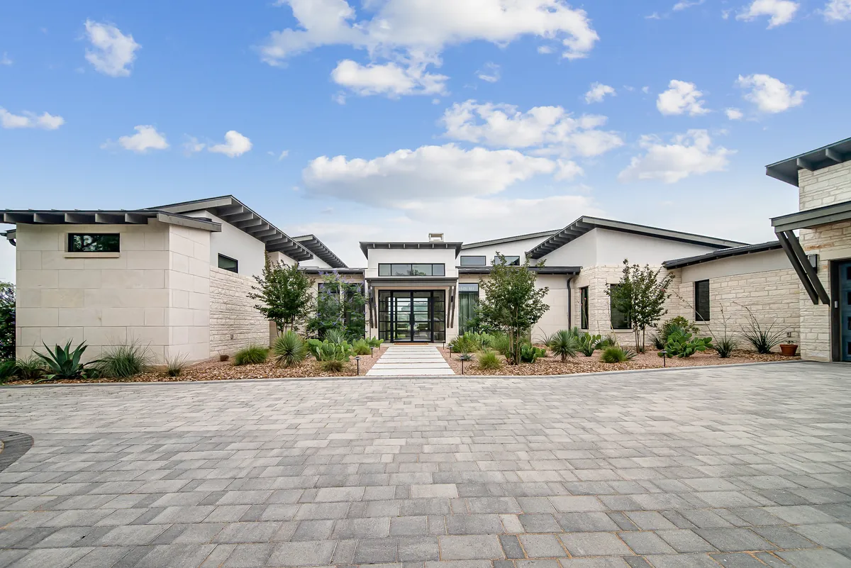 Stone home with wide paver motor court